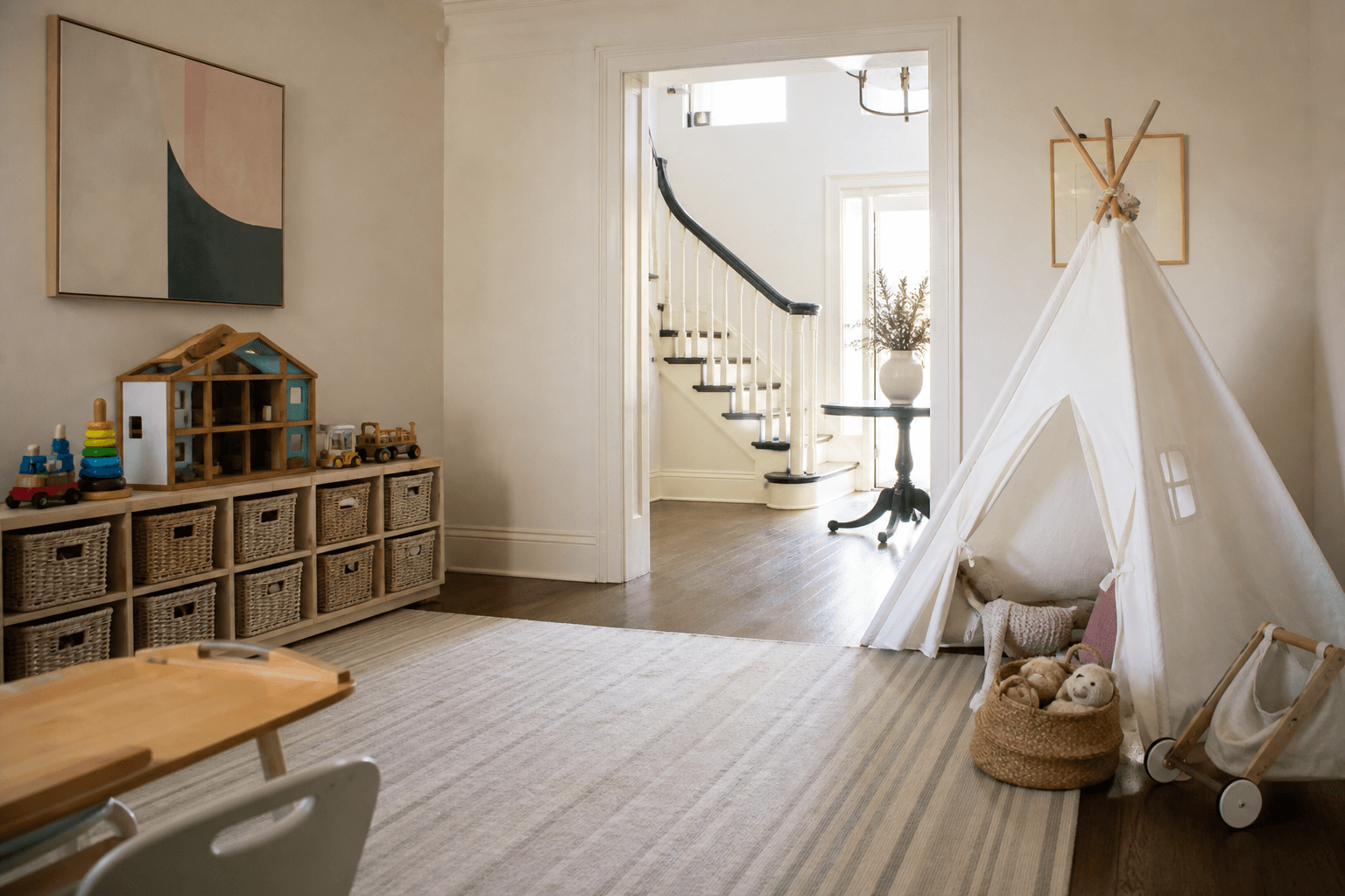 A child's bright playroom with a canvas teepee, a small dollhouse, woven baskets of toys, and a striped rug.